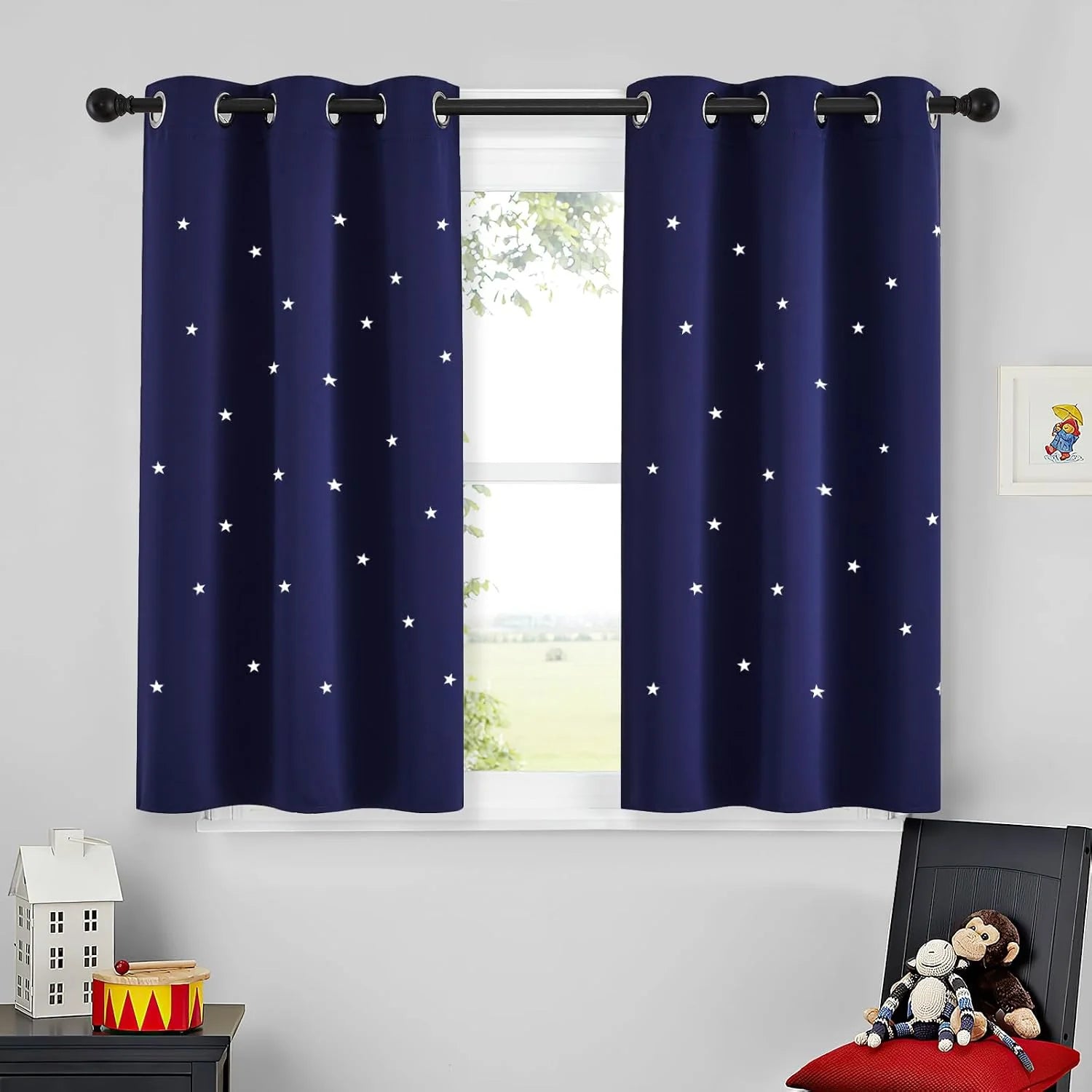 Navy blue star-pattern blackout curtains with silver grommets in a kids room window