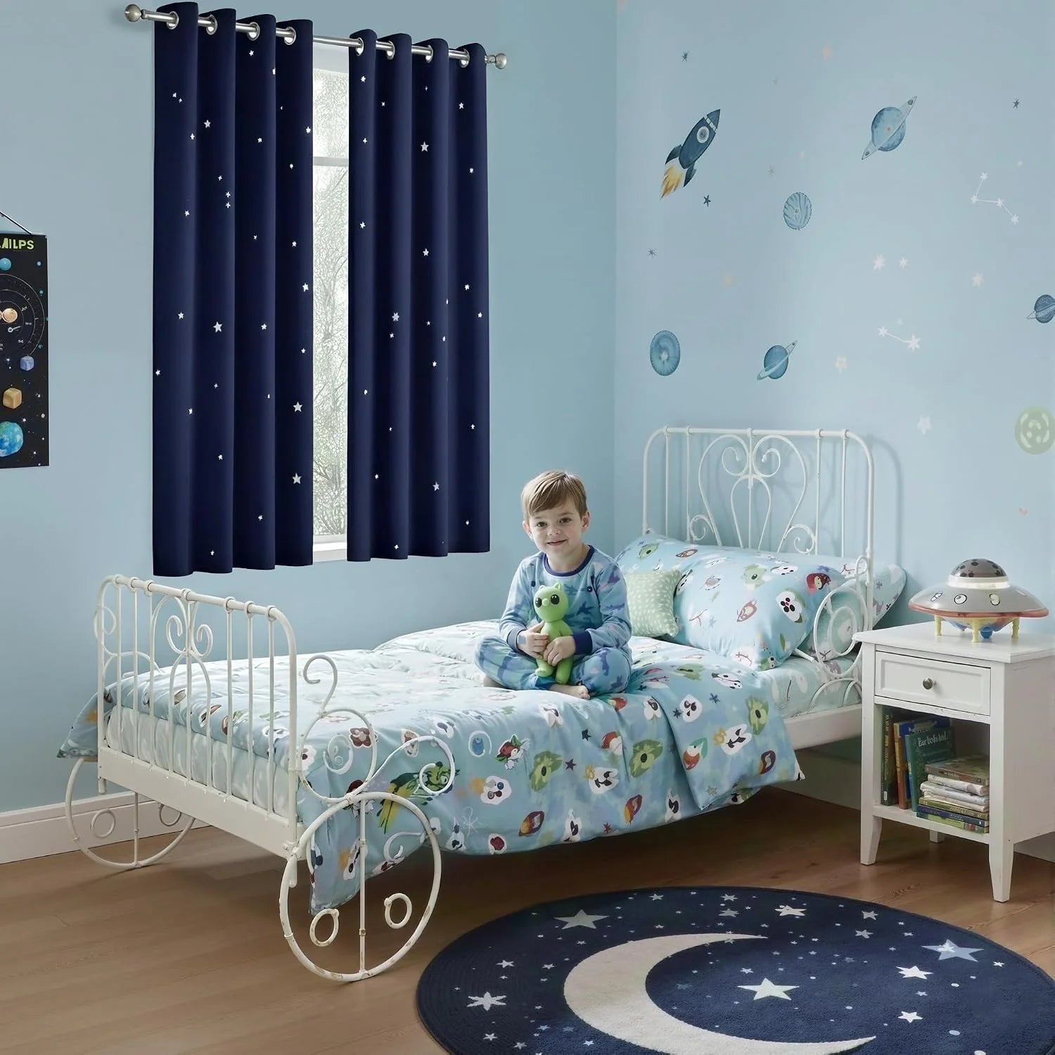 Navy star-pattern blackout curtains in a light blue kids bedroom with space decor