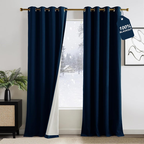 Navy blue velvet blackout curtains with grommet tops and white lining, visible in a room.