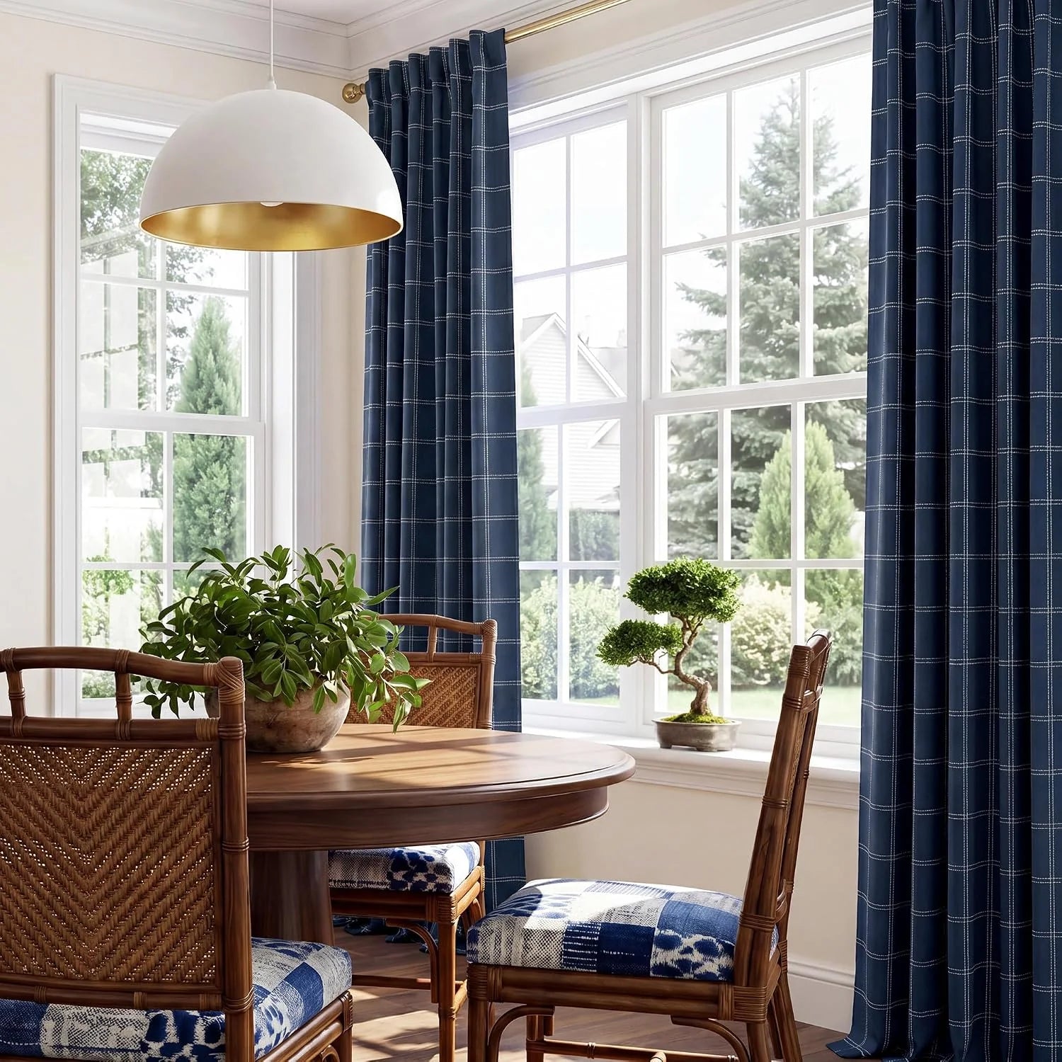Navy windowpane curtains framing bright dining room windows with wicker chairs