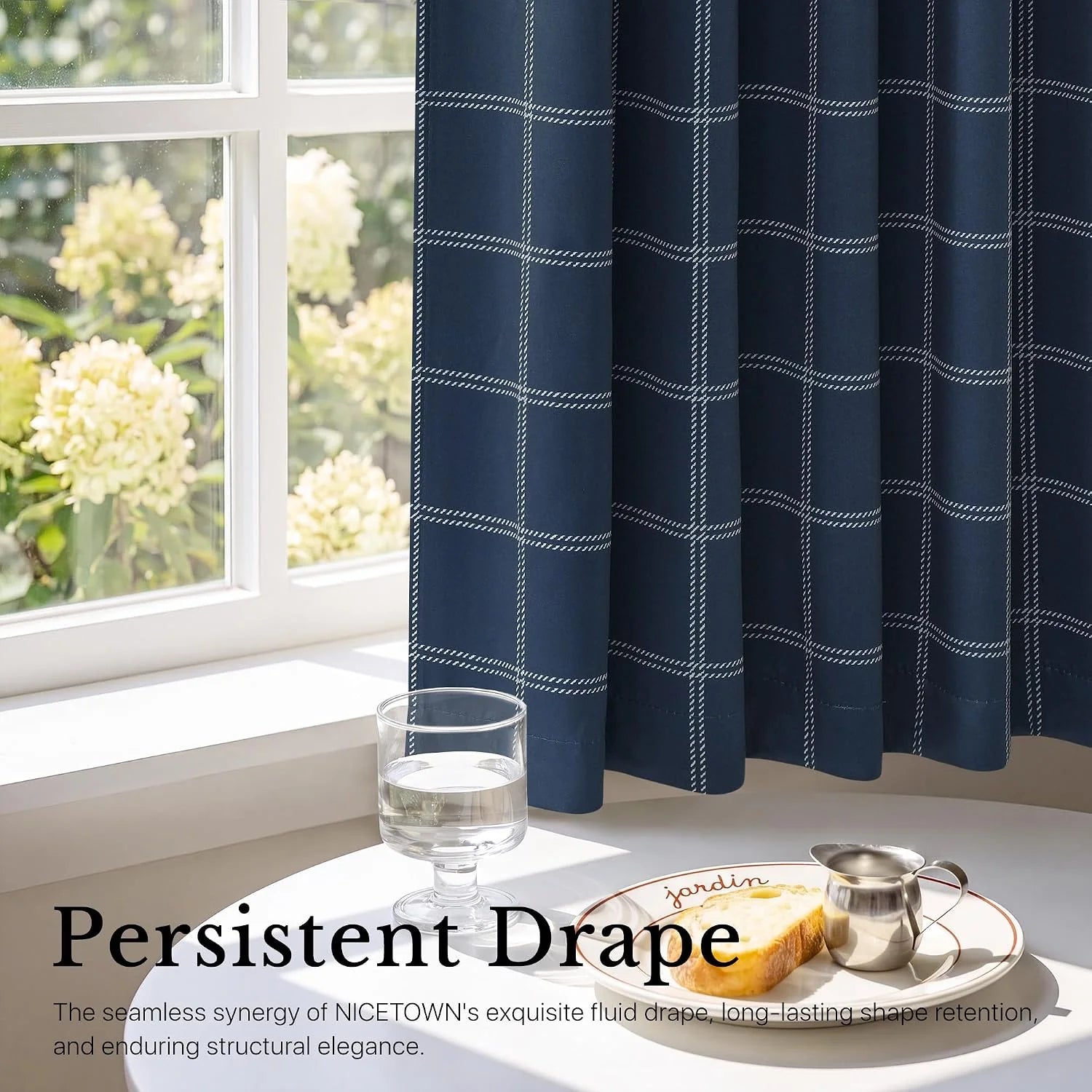 Navy windowpane tier curtain beside a bright white window over a breakfast table
