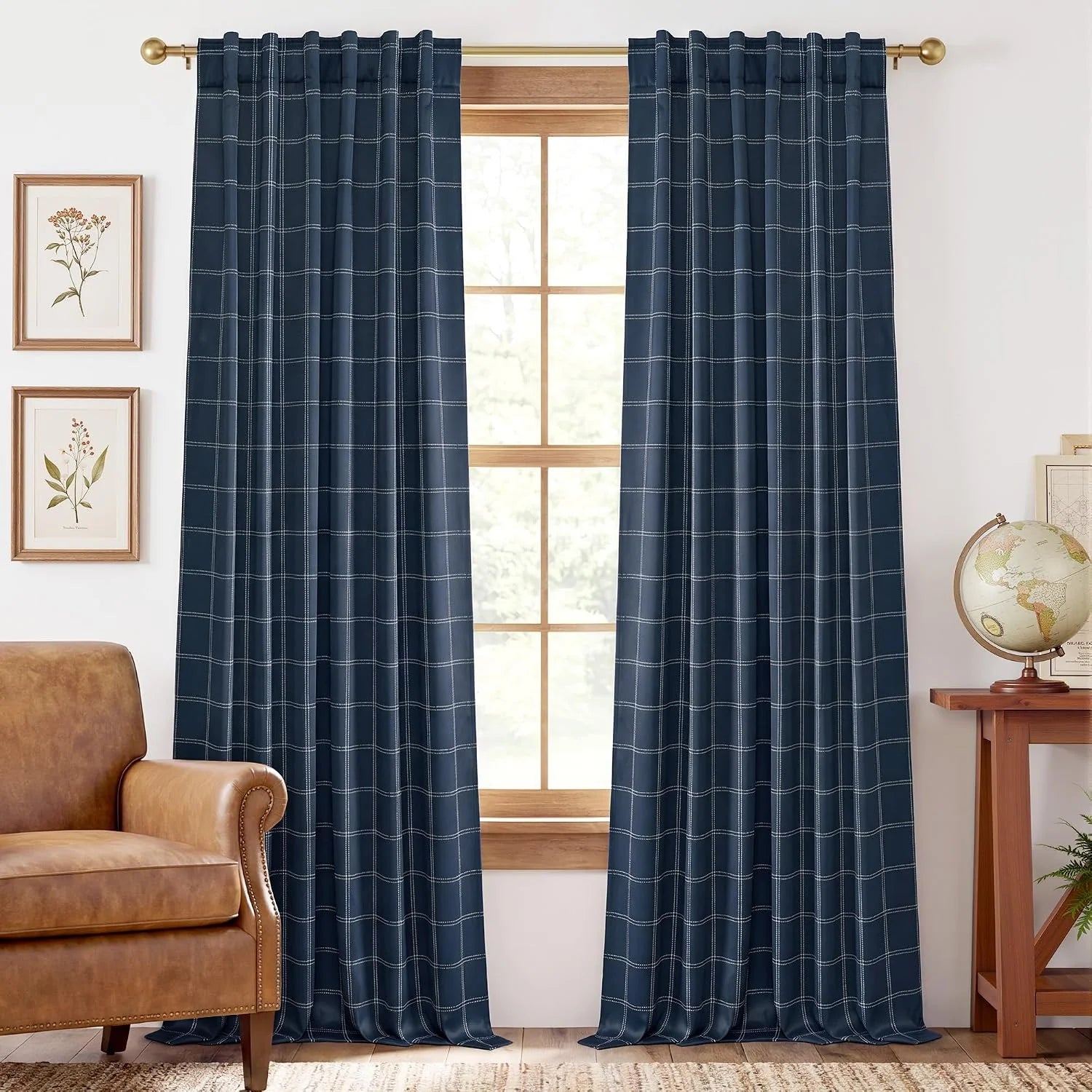 Navy blue windowpane plaid curtains on a brass rod in a bright living room