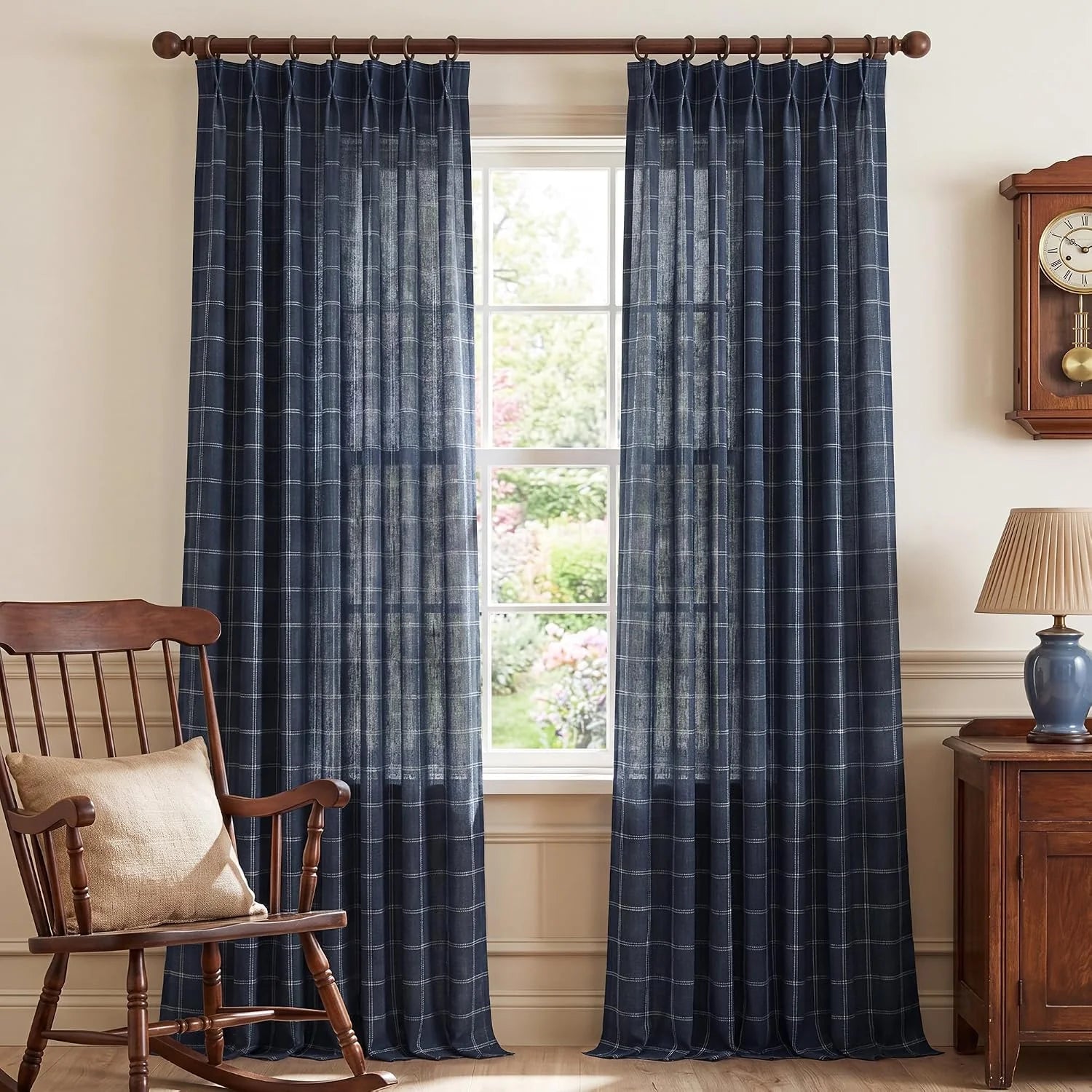 Navy windowpane sheer curtains on a wood rod in a cozy traditional room