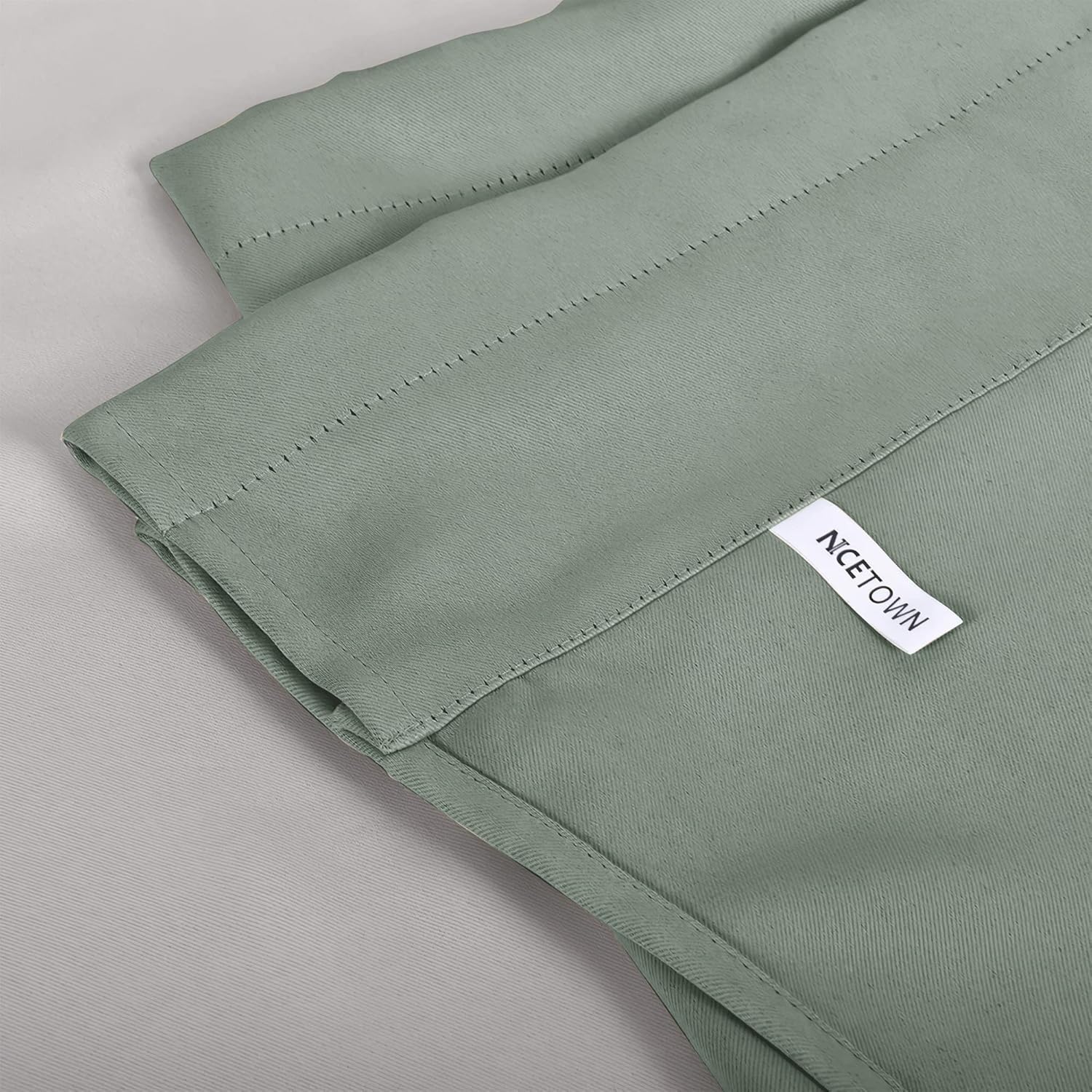 Textured sage green curtain panel showing detailed stitching on a thick fabric, with NCETOWN brand label.