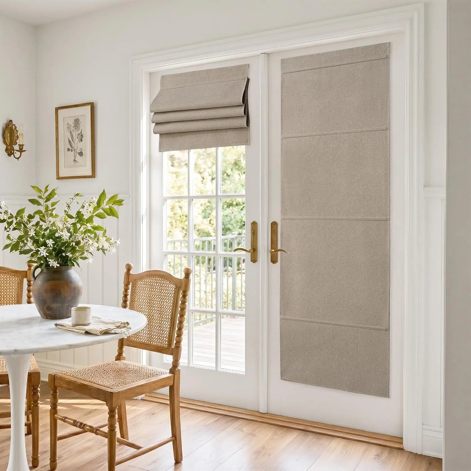 Neutral beige linen roman shades on white French doors in a bright dining room with a marble table.