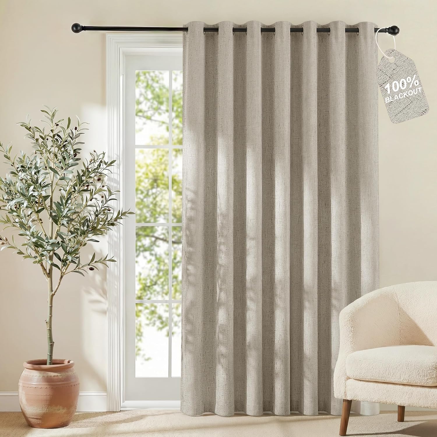 Textured light beige grommet top 100% blackout curtain panel hanging on a black rod.