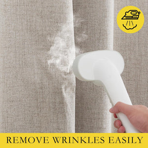 Close-up shows a white handheld steamer removing wrinkles from a textured oatmeal linen blend curtain.