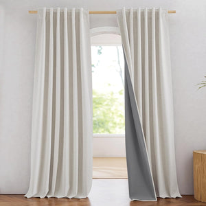 Oatmeal textured linen curtains with dark grey blackout lining hanging from a wooden rod.