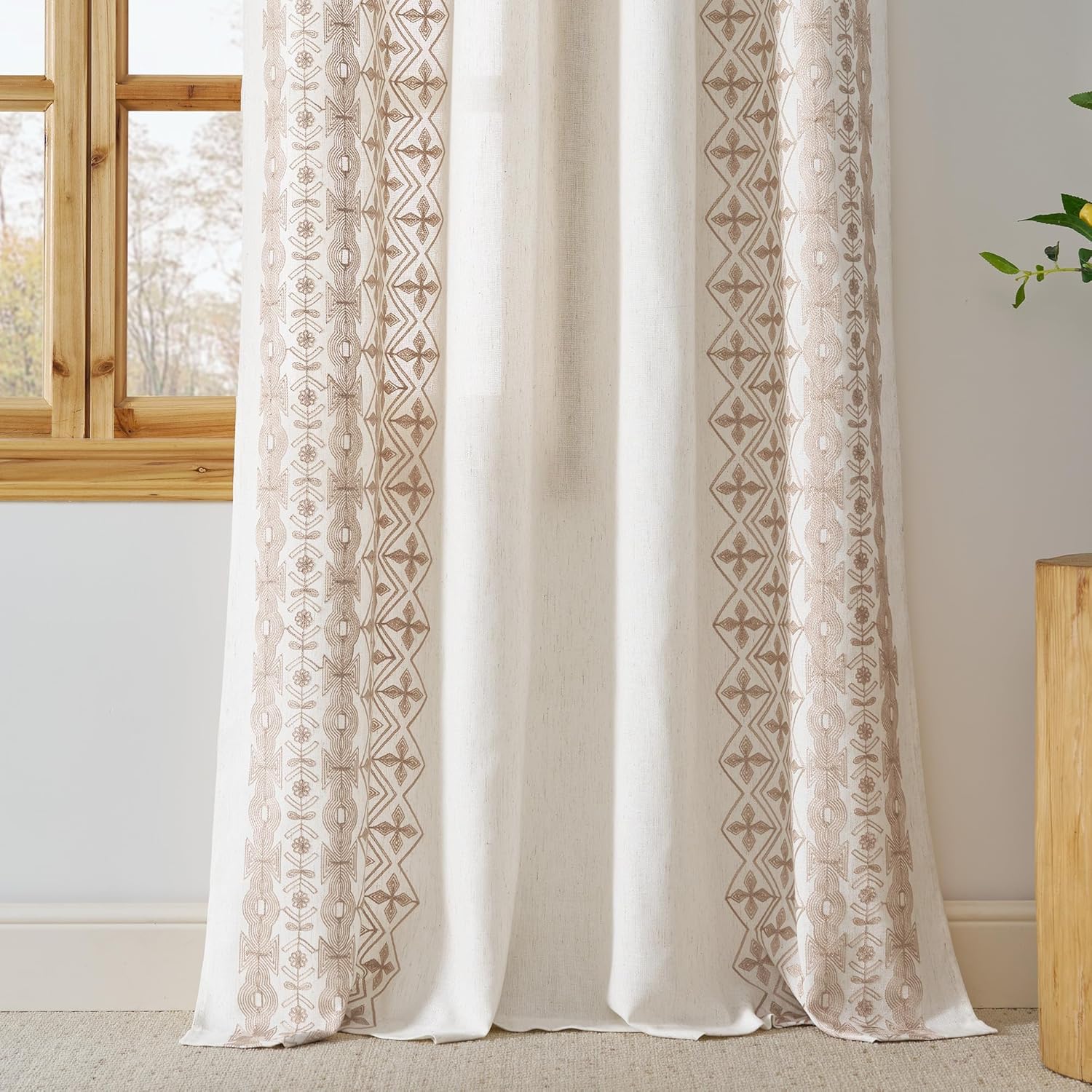 Off-white linen curtain panel featuring intricate light brown bohemian embroidery.