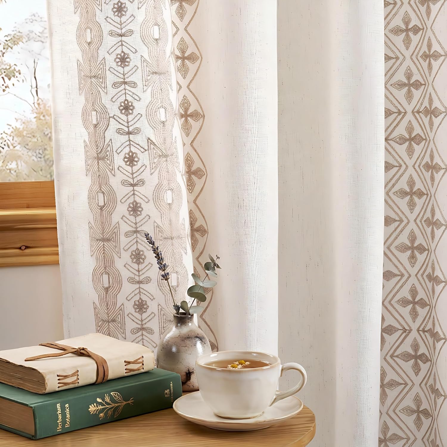 Natural off-white sheer curtains with textured beige bohemian embroidery, complementing a cozy window scene.