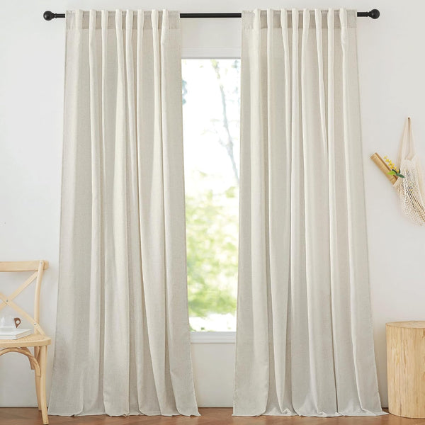 Pair of light beige linen back tab curtains with a natural texture hanging on a black rod.
