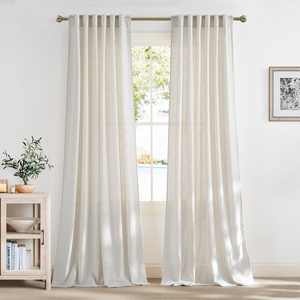 Textured off-white linen blend back tab curtains softly draped at a window, filtering natural light.