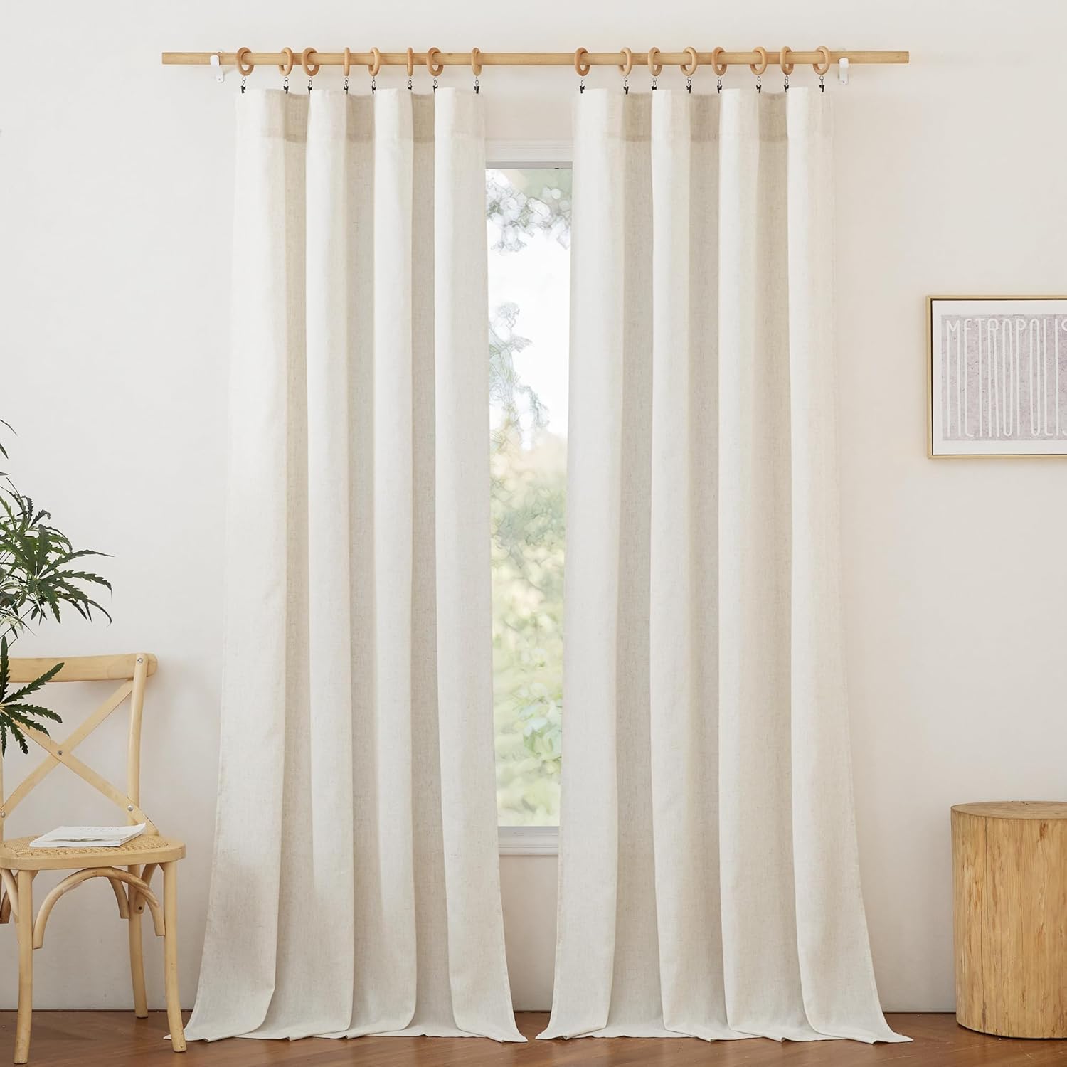 Pair of off-white textured linen curtains with wooden clip rings on a natural rod.