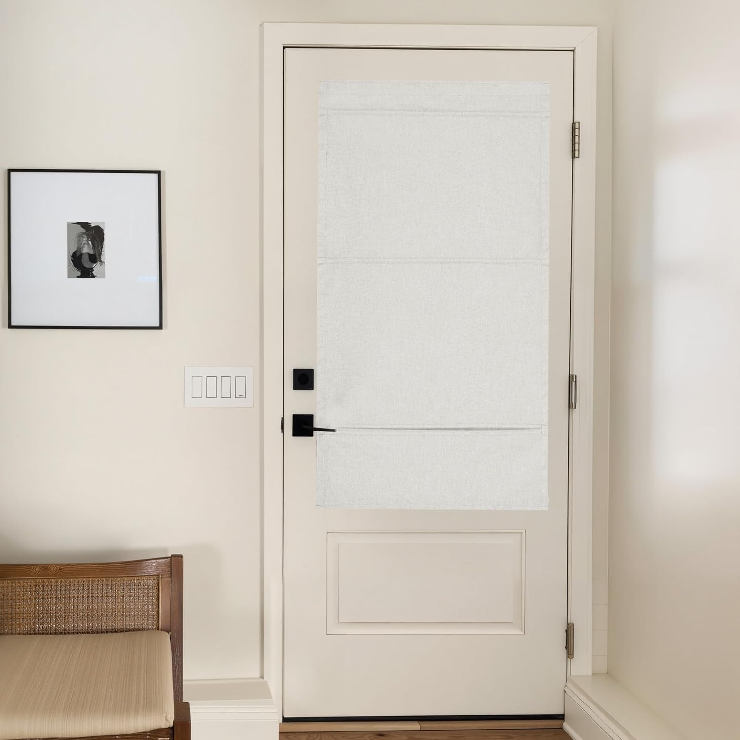 Off-white linen flat fold roman shade covering the top panel of a white door.