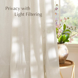 Off-white linen-look light filtering curtain provides privacy, letting soft sunlight into a bright room with flowers.