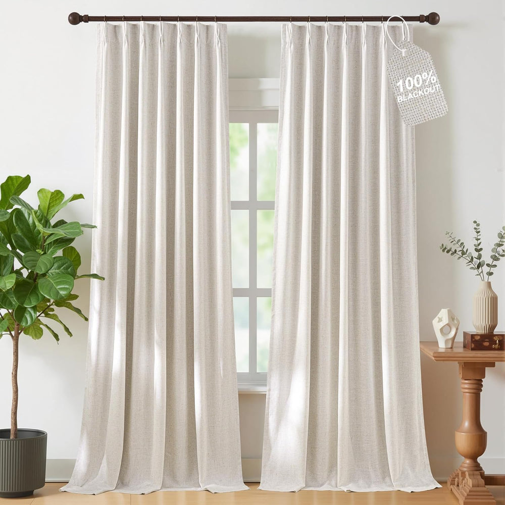 Natural linen off-white pinch pleat curtain panel hanging from a dark wood rod with brass rings.
