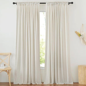Two off-white linen-textured rod pocket curtains on a black rod, filtering natural light.