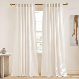Off-white linen tab top curtains hanging on a window rod, providing light filtering privacy in a bright room.