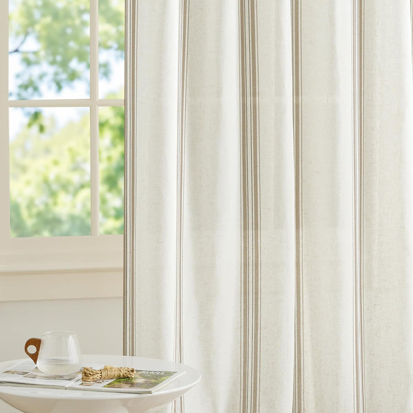 Light filtering off-white curtain with thin and thick vertical taupe stripes, diffusing light from a window.