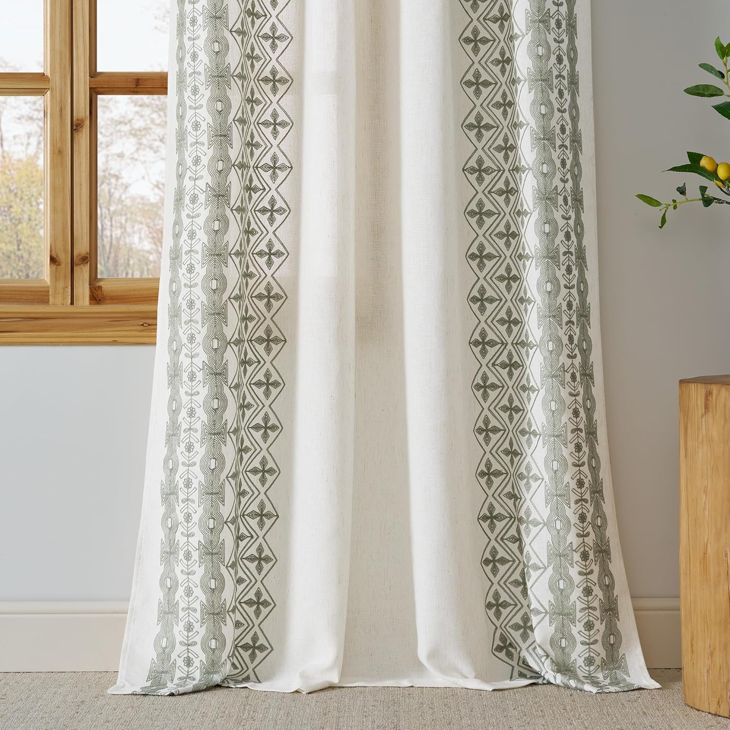 Off-white linen curtain panel with vertical sage green geometric and botanical embroidered patterns.