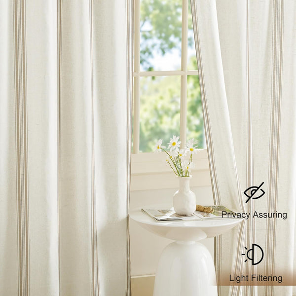 Off-white linen-blend curtains featuring subtle vertical tan stripes, draped over a window.