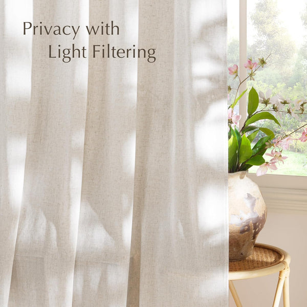 Textured off-white linen light filtering curtains hanging gracefully by a sunlit window, providing soft privacy.