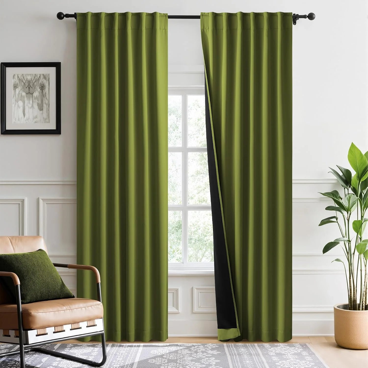 Olive green blackout curtains with black lining hanging on a rod in a bright modern room