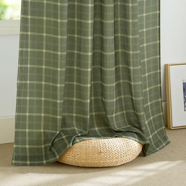 Olive green and beige plaid window curtains softly draped, resting on a woven pouf.