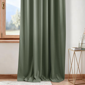 Full length olive green blackout curtain panel with soft folds, hanging by a wooden window.