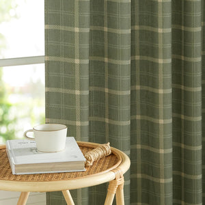 Olive green plaid woven window curtain with beige check pattern, hanging beside a window.