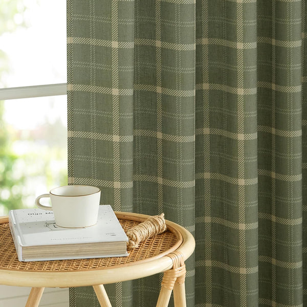 Olive green plaid woven window curtain with beige check pattern, hanging beside a window.