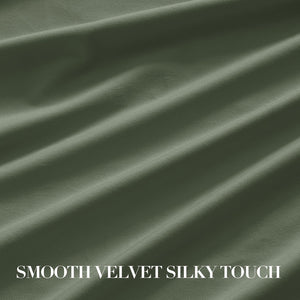 Close-up of a draped olive green velvet fabric, showcasing its smooth, silky texture and soft sheen.