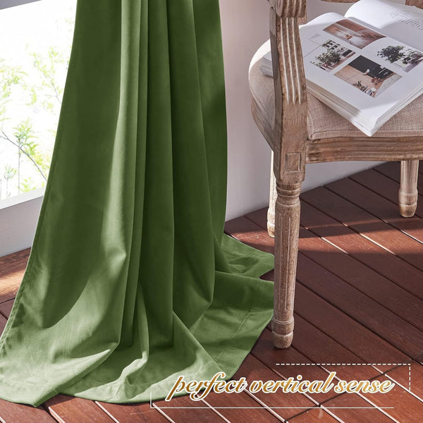 Soft olive green velvet curtain drapes elegantly by a window, pooling on a dark wood floor.