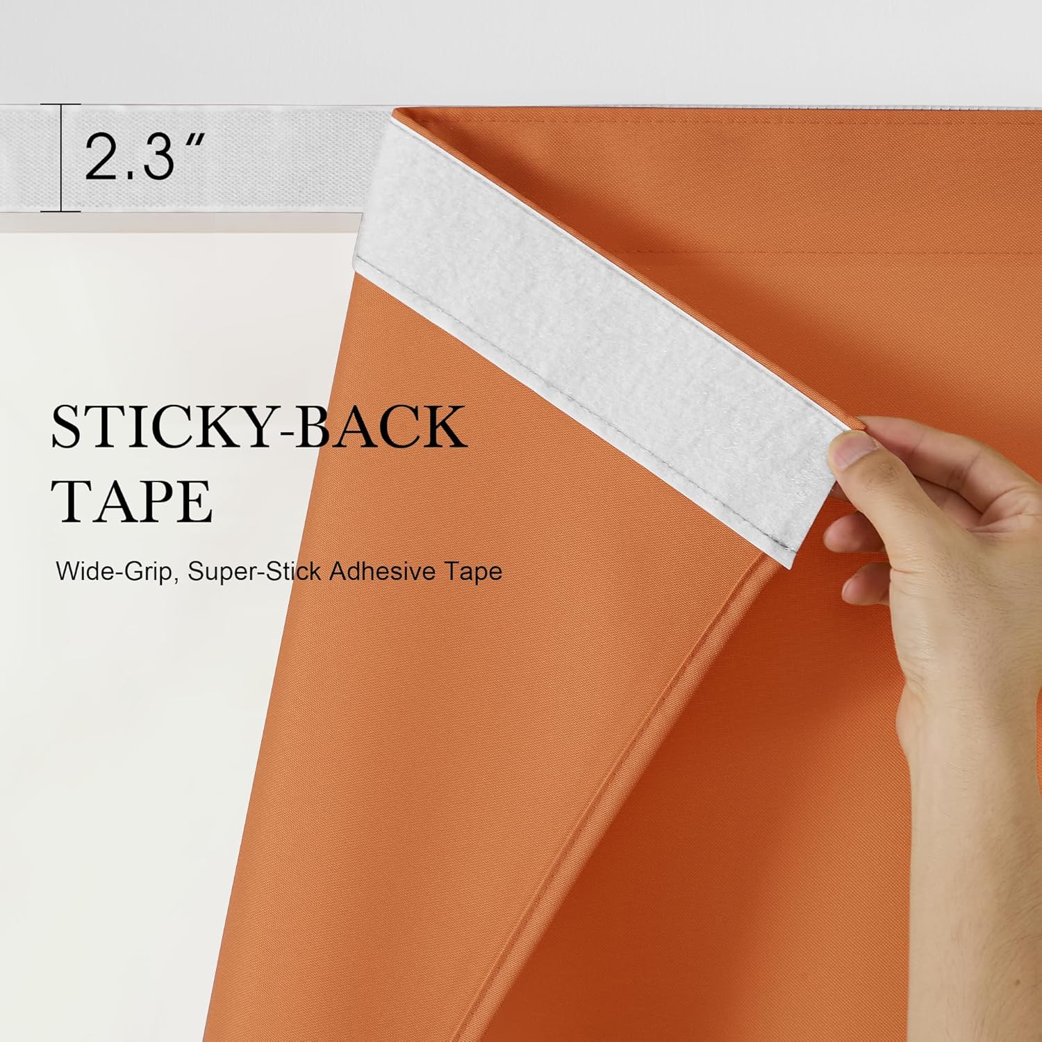 A hand peels back white 2.3 inch wide sticky-back tape from an orange textured curtain, revealing strong adhesive.