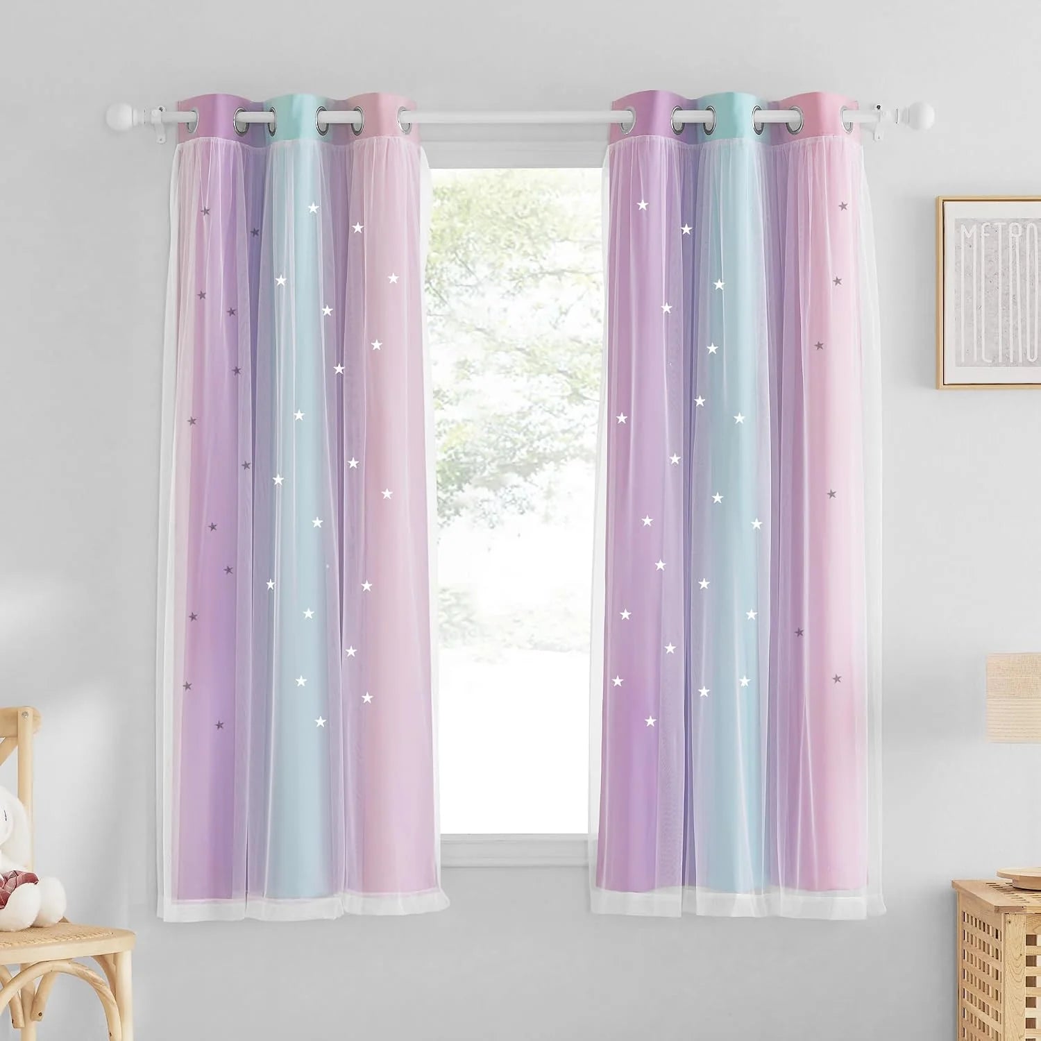 Pastel pink and blue sheer star curtains with grommet top in a bright kids bedroom