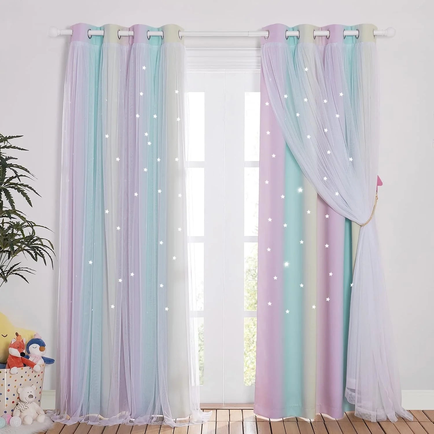 Pastel rainbow curtains with sheer star overlay hanging in a bright kids bedroom