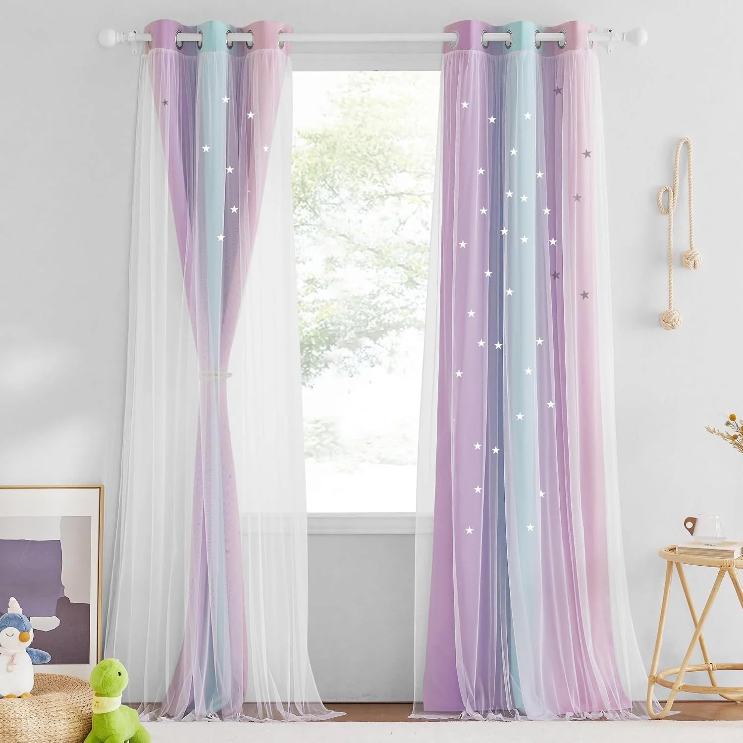 Pastel rainbow sheer curtains with star cutouts hanging on a white grommet rod
