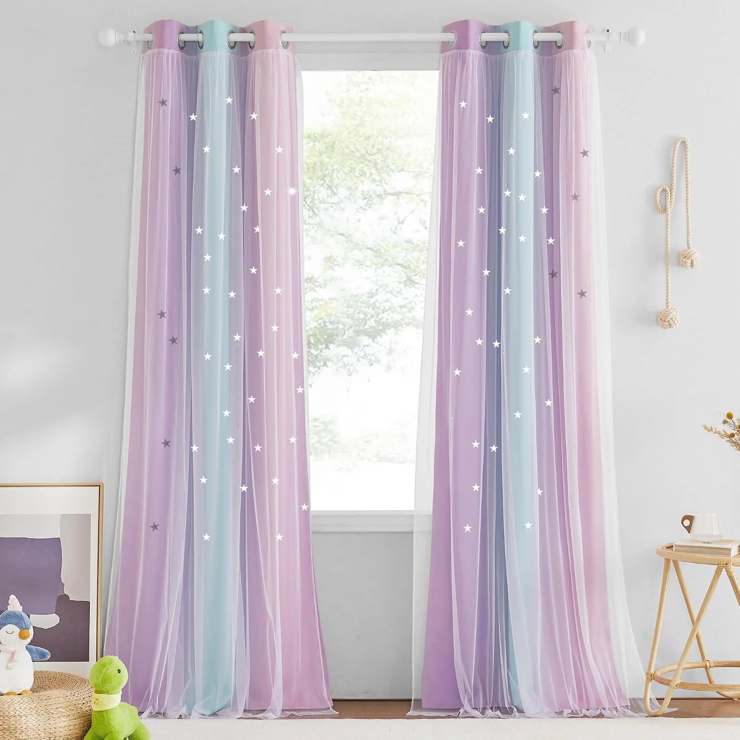 Pastel sheer curtains with star cutouts hanging on a white rod in a kids room