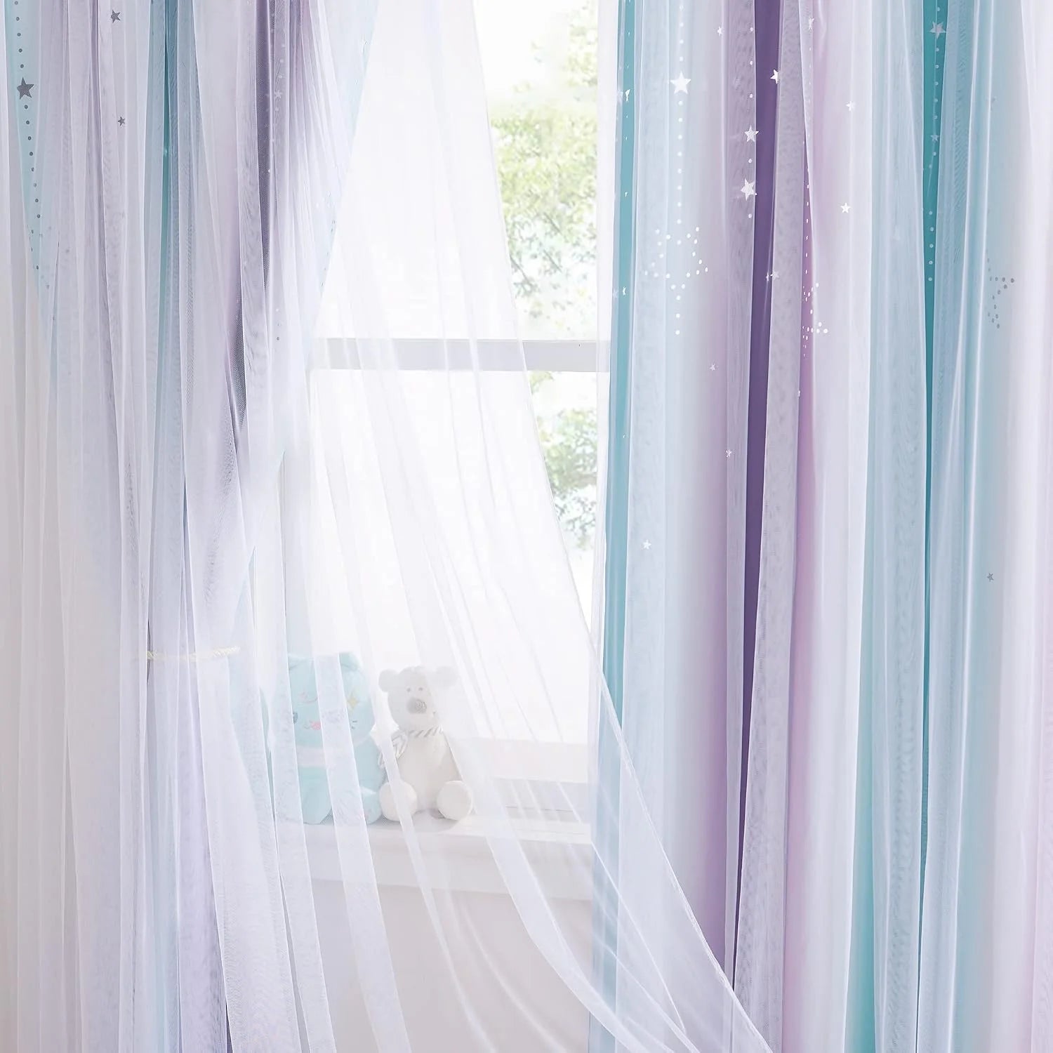 Pastel sheer star curtains draped over a bright nursery window with teddy bears