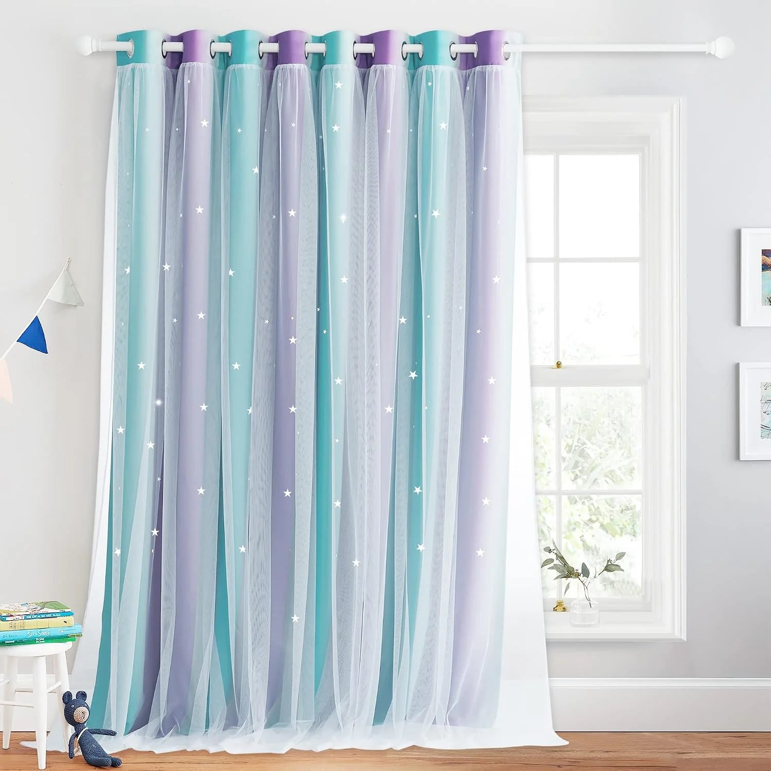 Pastel blue and purple sheer star curtain panel hanging in a bright kids bedroom