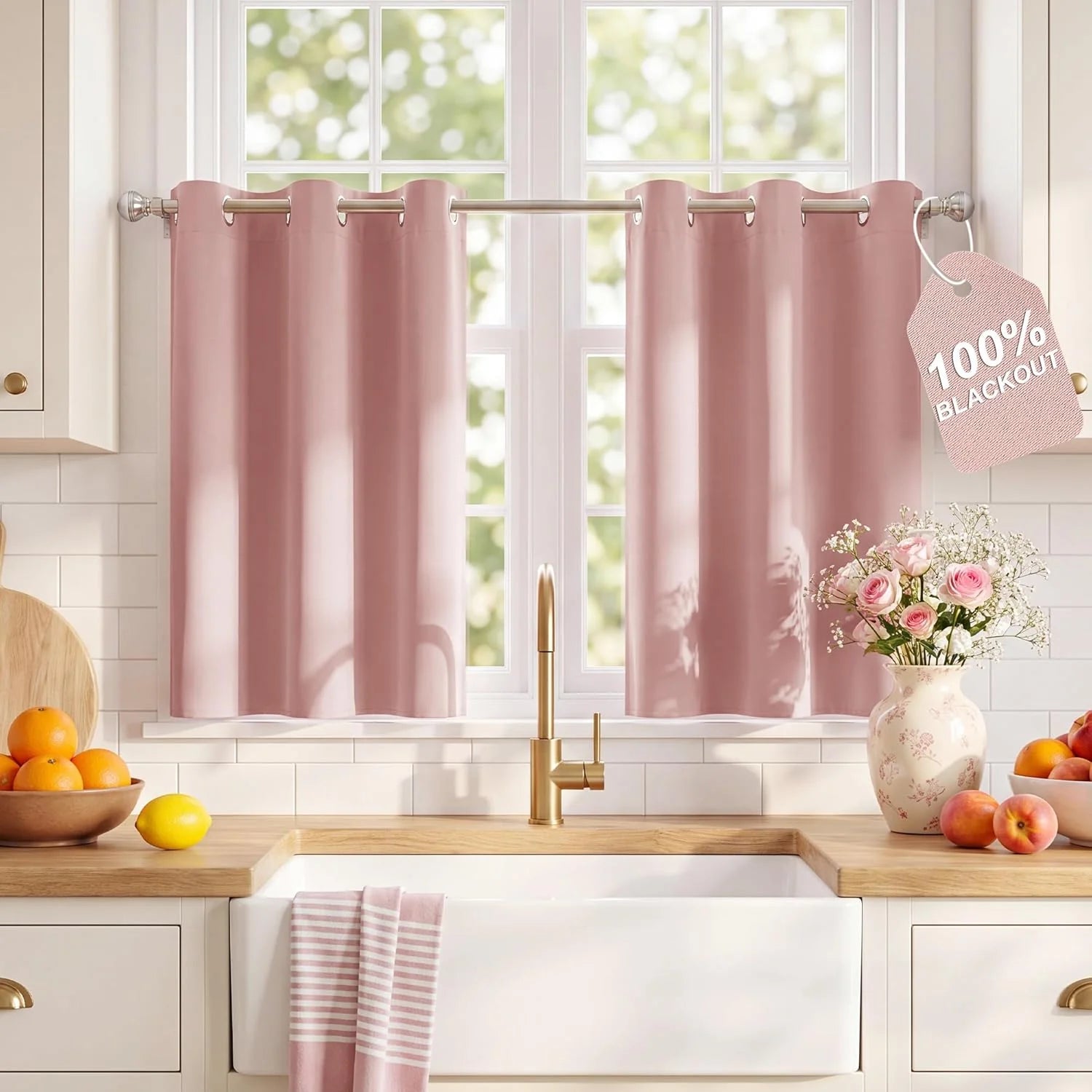 Light pink blackout tier curtains with grommet tops hanging in a bright kitchen window above a farmhouse sink.