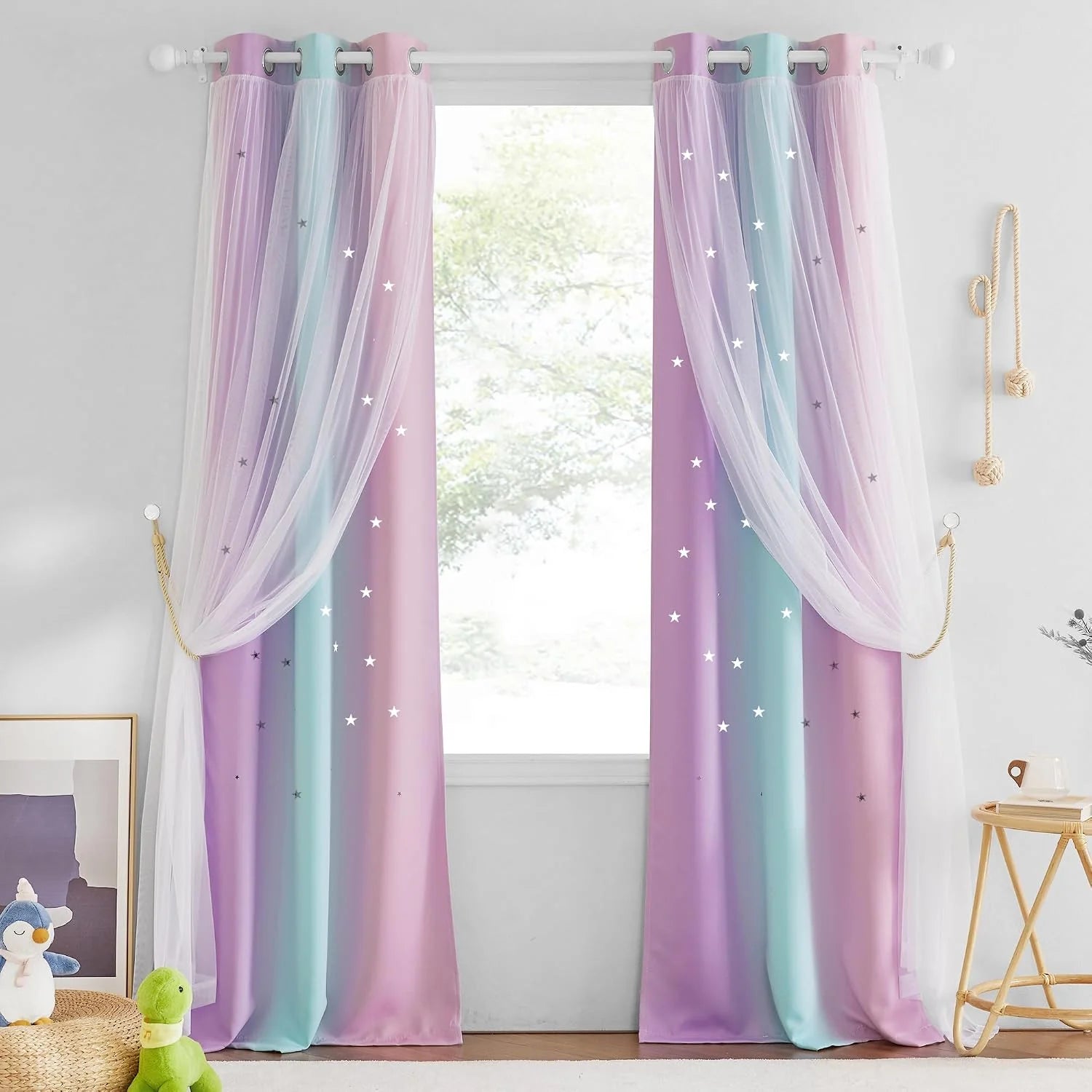 Pink and blue star curtains with sheer overlay in a bright kids bedroom