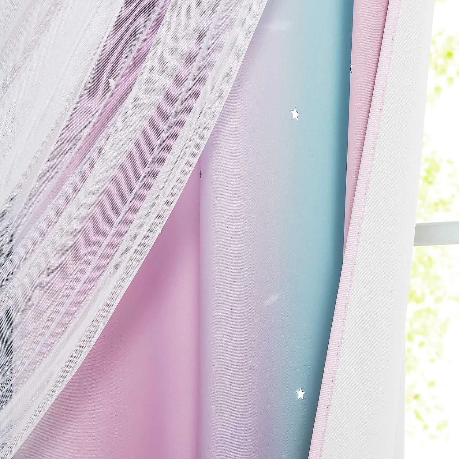 Pink and blue sheer curtains with small star details by a bright window