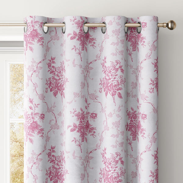 White curtain featuring a pink floral toile pattern with a grommet top, hanging on a gold rod.