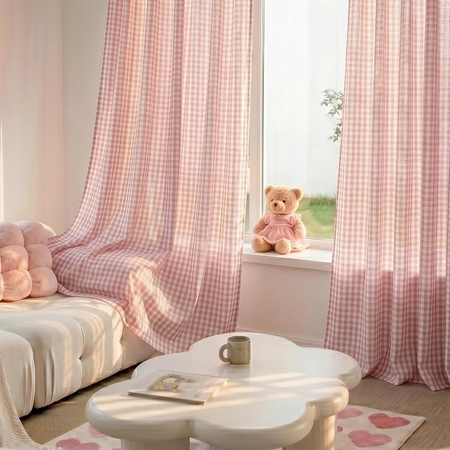 Light pink gingham sheer curtains in a sunny living room with a white sofa, cloud table, and teddy bear.