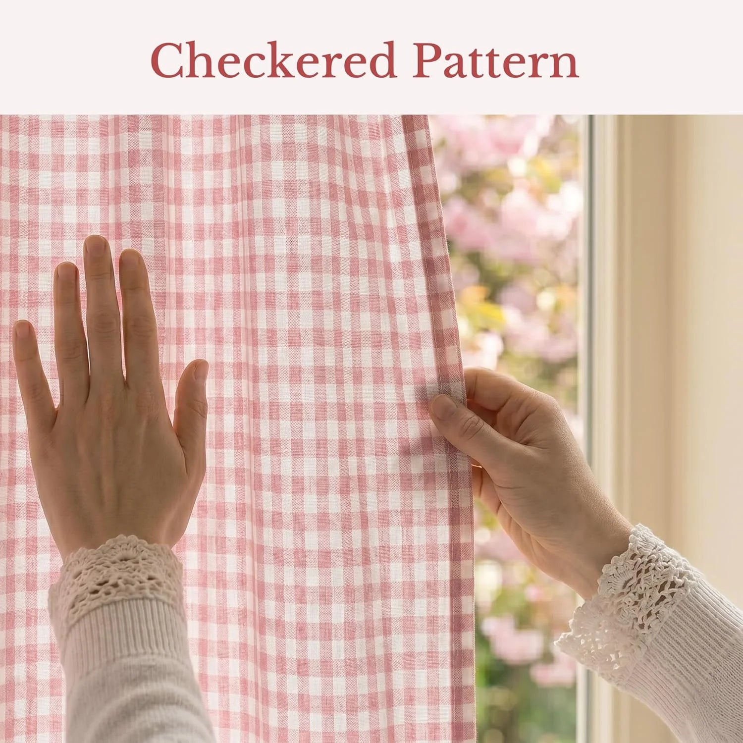 Close-up of hands adjusting a pink and white checkered gingham curtain by a window.