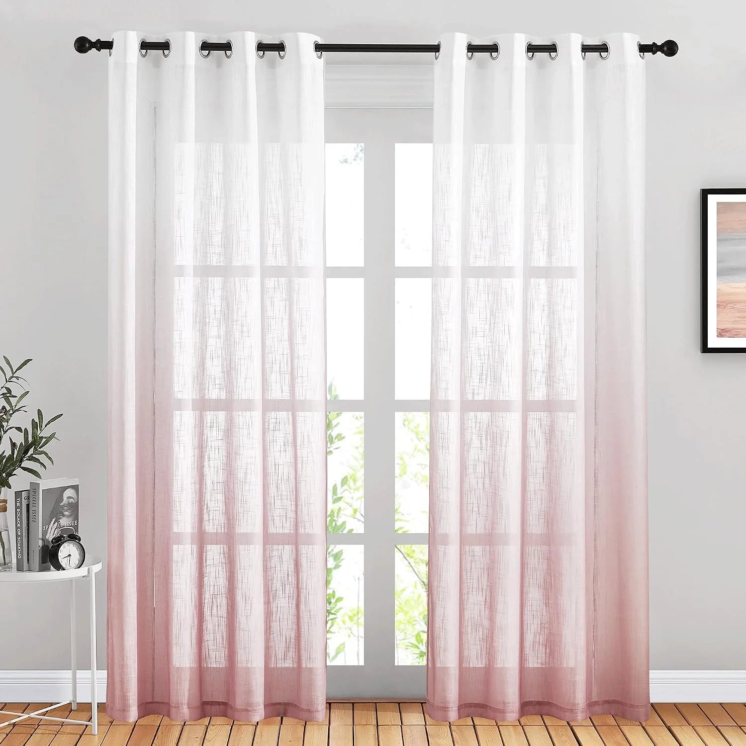 White to blush pink ombre sheer curtains with black grommets on a window