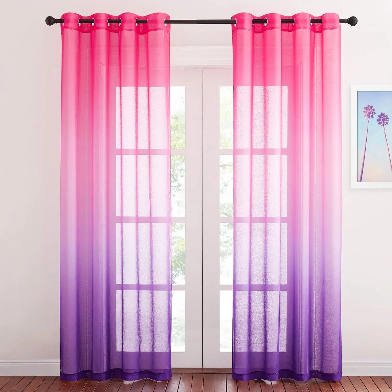 Pink to purple ombre sheer curtains with grommet top on a bright window