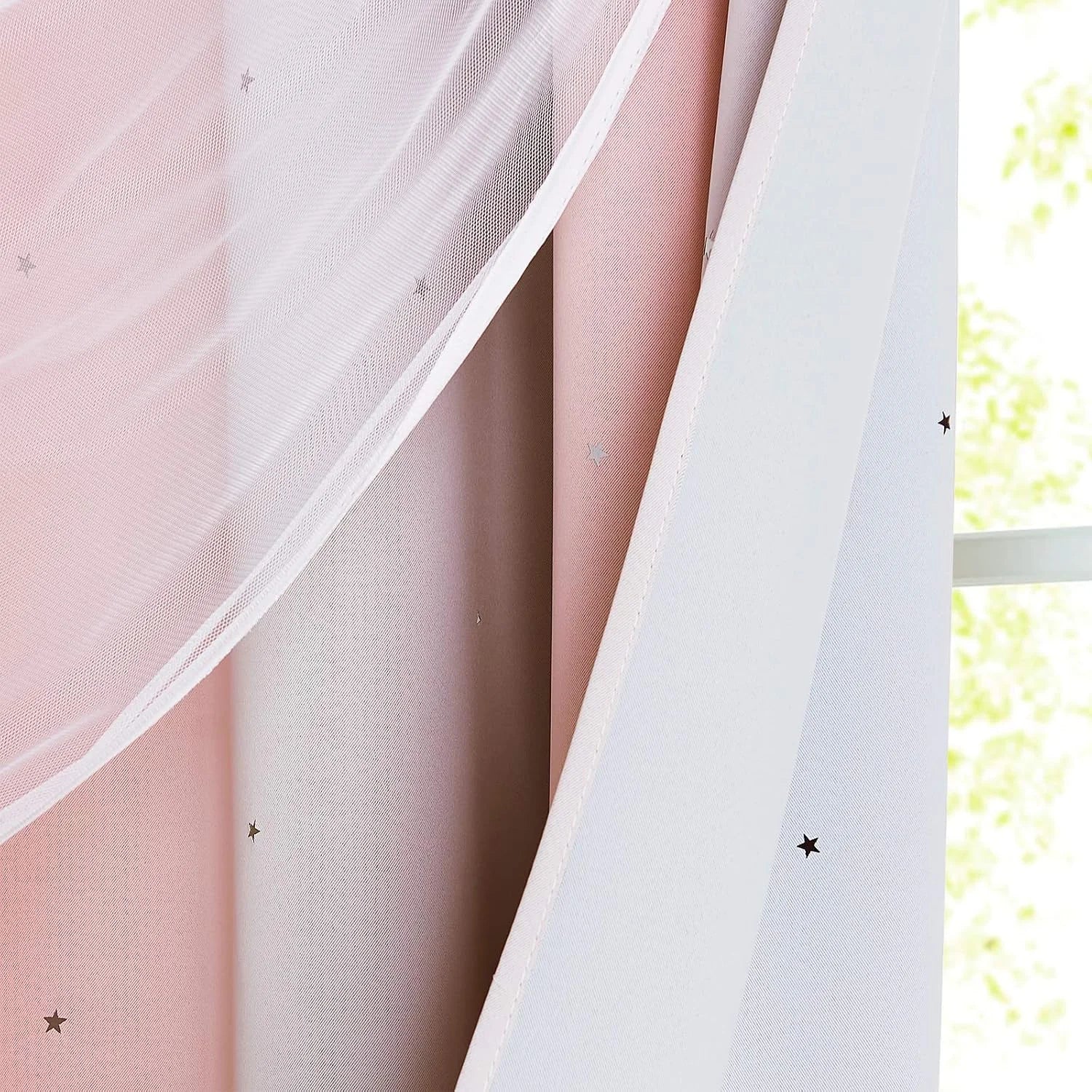Pink and white layered curtains with sheer mesh and tiny star details by a window