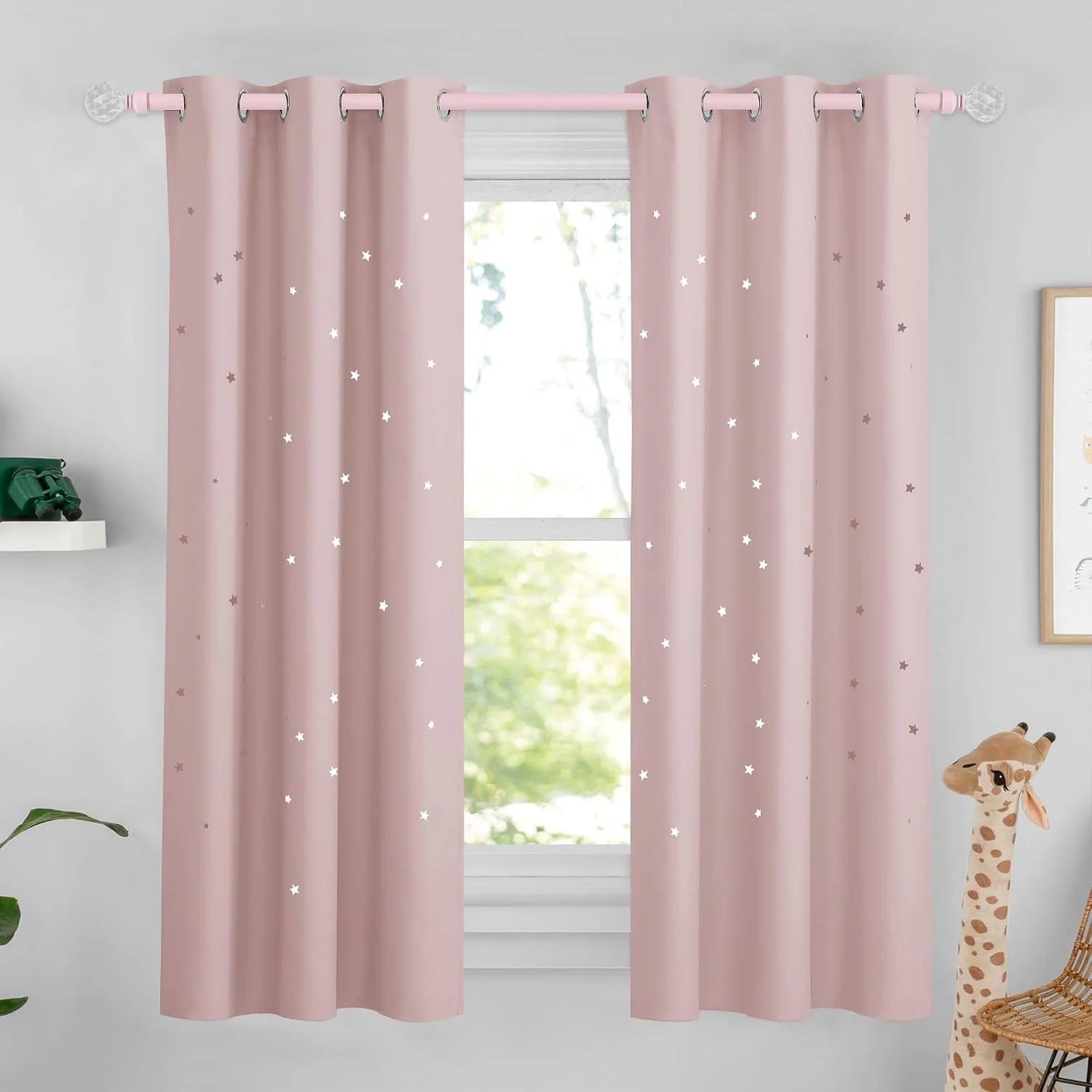 Blush pink star blackout curtains with silver grommets in a kids bedroom window